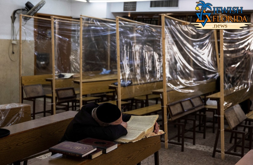 An ultra-Orthodox Jewish man studies in a Yeshiva, or Jewish seminary, equipped with partitions to protect against the spread of the coronavirus disease (COVID-19), in the Mea Shearim neighbourhood of Jerusalem March 2, 2021. (credit: RONEN ZVULUN/REUTERS)